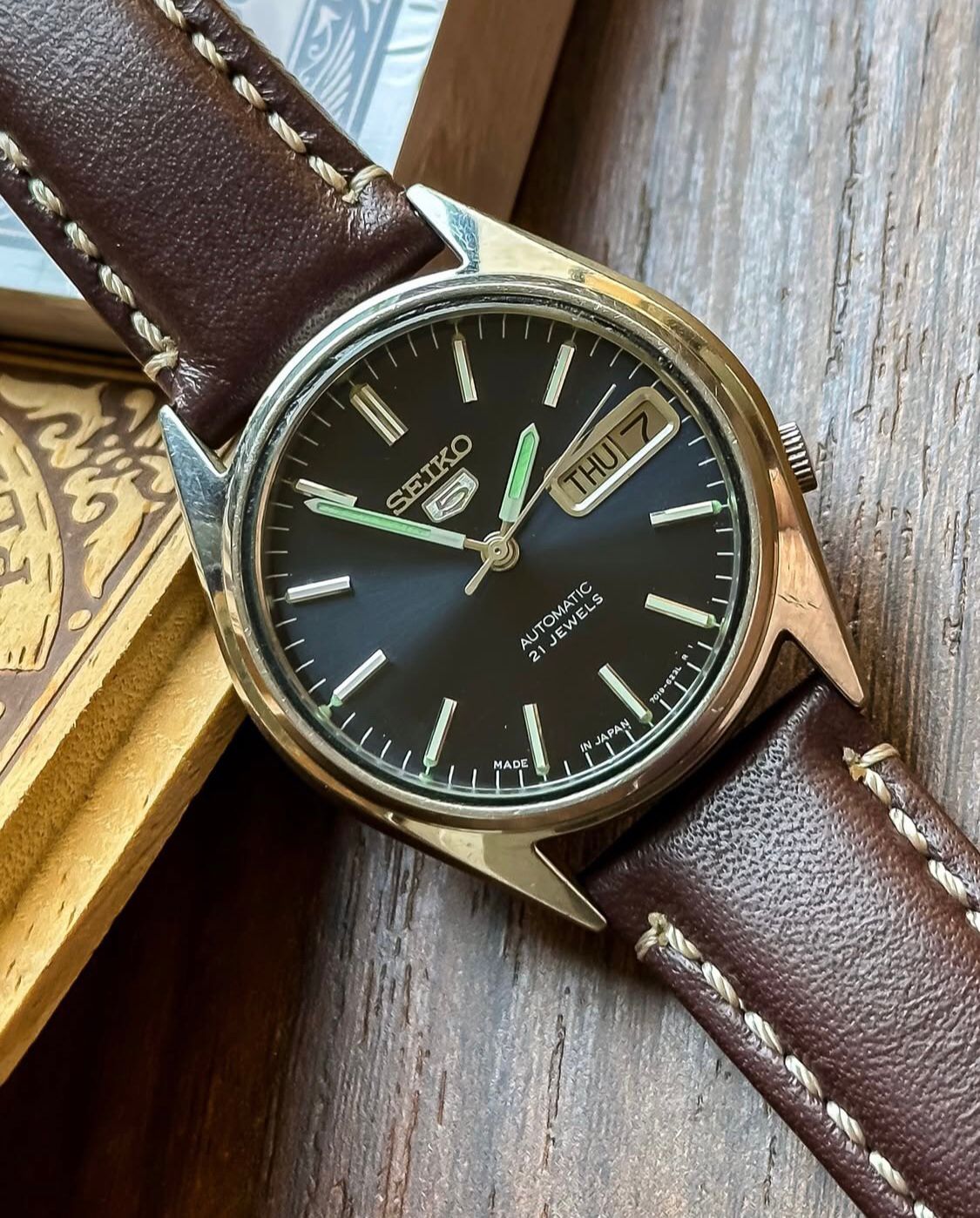 Vintage Seiko 5 Automatic watch with a navy blue dial and a brown leather strap