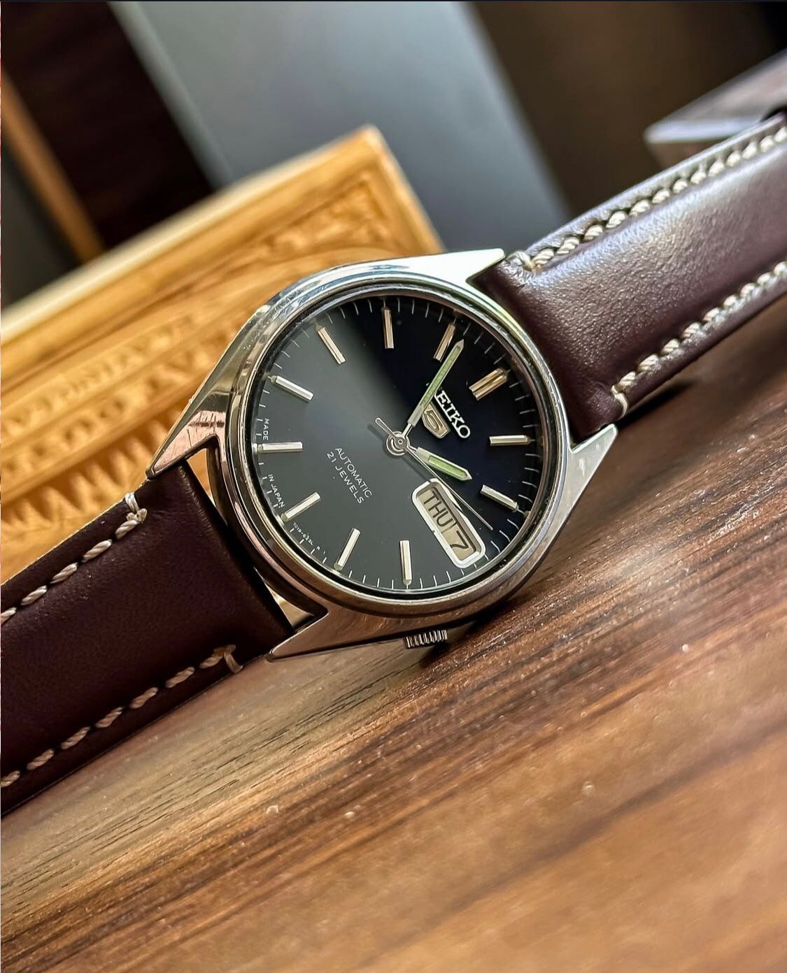 Vintage Seiko 5 Automatic watch with a navy blue dial and a brown leather strap