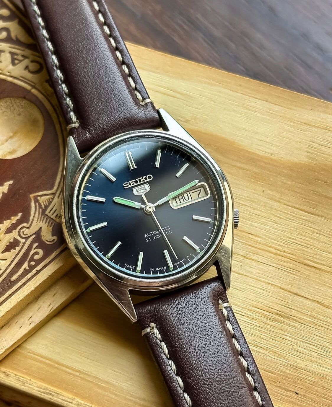 Vintage Seiko 5 Automatic watch with a navy blue dial and a brown leather strap
