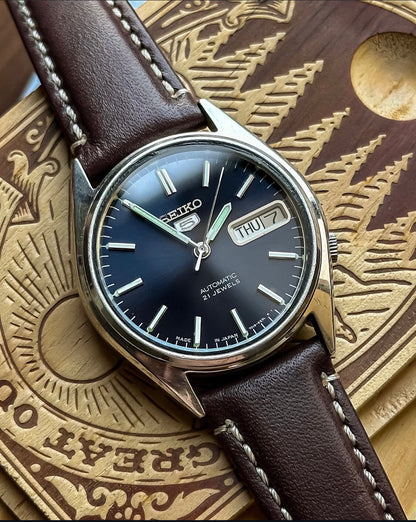 Vintage Seiko 5 Automatic watch with a navy blue dial and a brown leather strap
