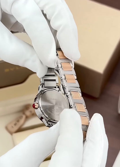 Bvlgari  watch with a stainless steel and rose gold case, diamond bezel, and a red dial.