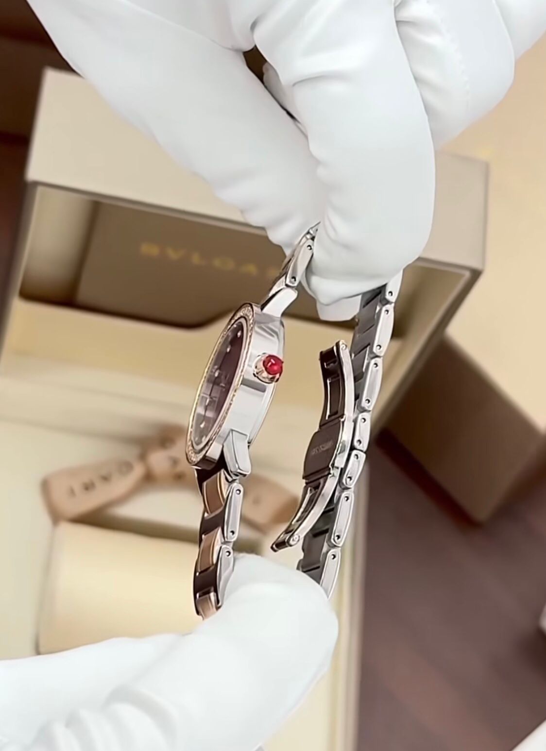 Bvlgari  watch with a stainless steel and rose gold case, diamond bezel, and a red dial.