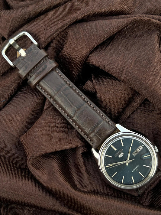 Vintage Seiko 5 Automatic watch with a navy blue dial and a brown leather strap